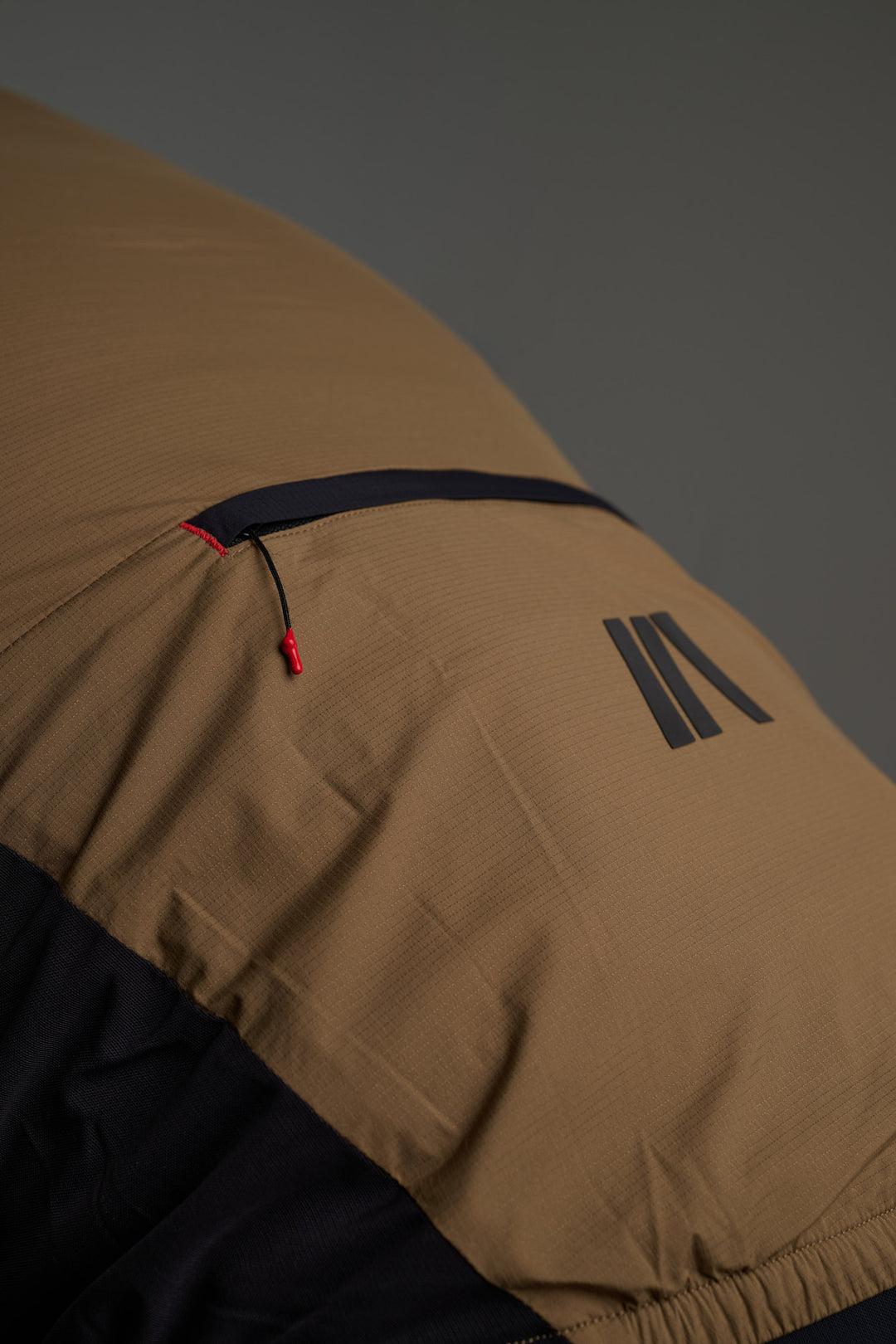 Bolsillo trasero con cremallera de doble sentido, diseñado para cerrarse tanto durante el uso como una vez el chaleco está plegado en su interior.