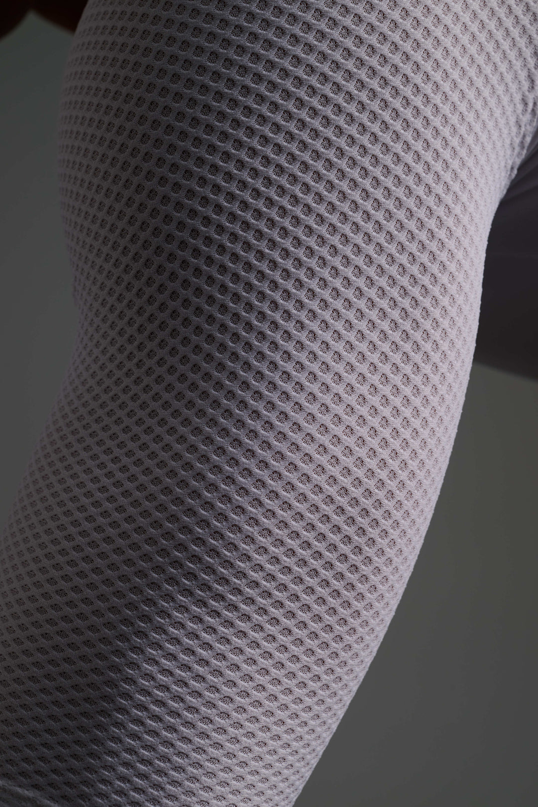 Tejido técnico con microperforaciones que se adapta al brazo con precisión, aportando compresión ligera y mejorando la ventilación en condiciones de intensidad.